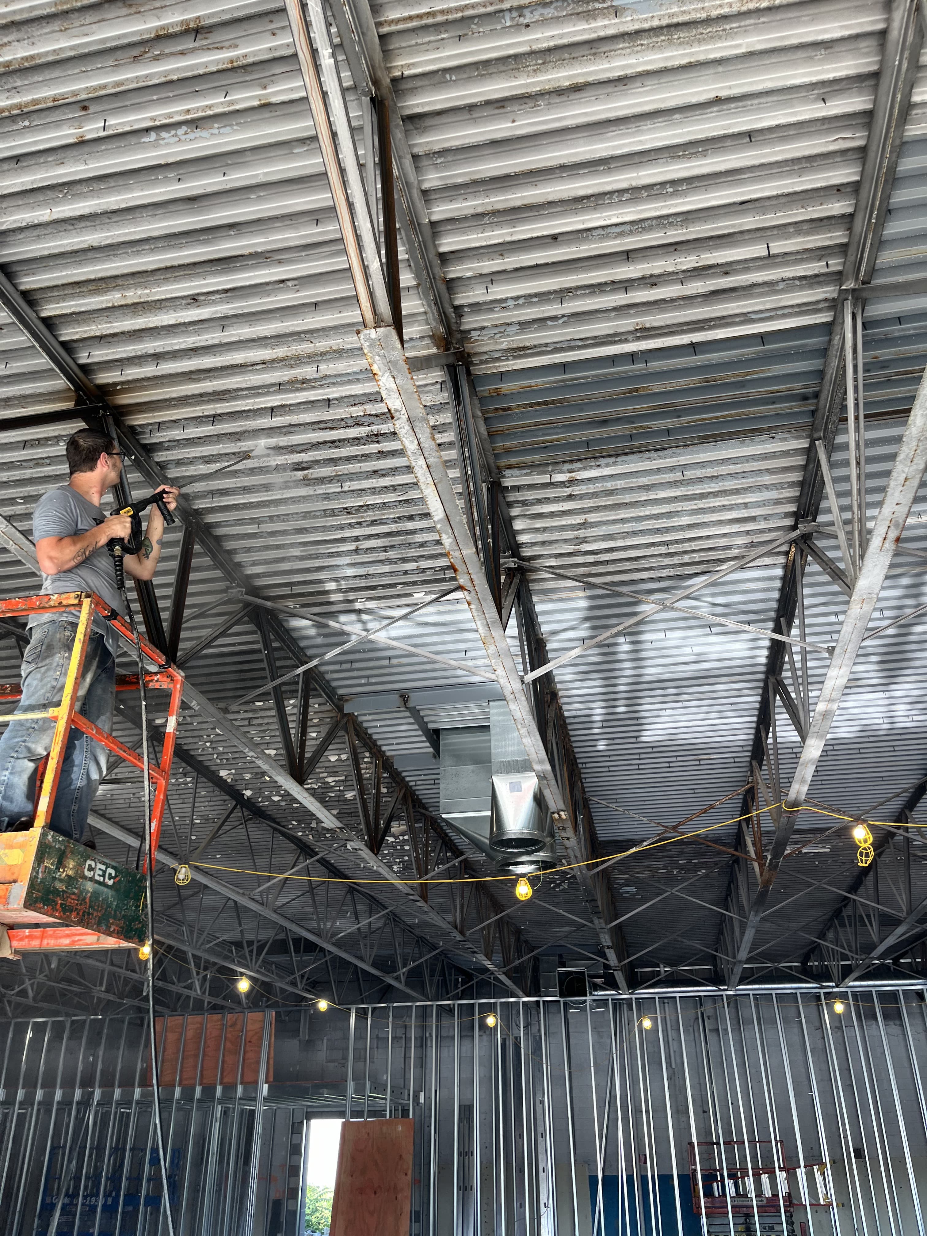 Large commercial bay interior during overhead renovation work.