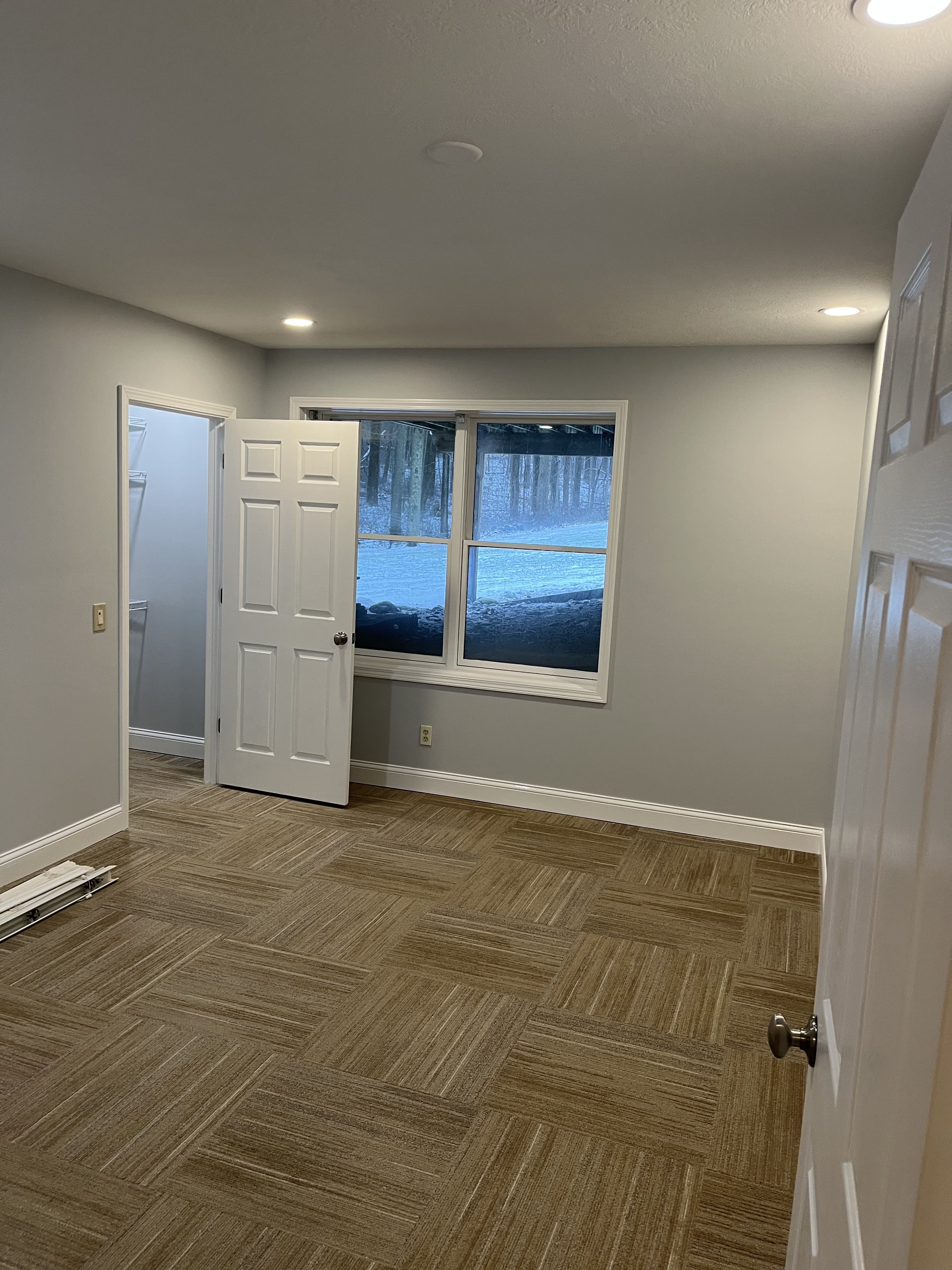 Finished room with carpet tile, recessed lighting, and fresh paint.
