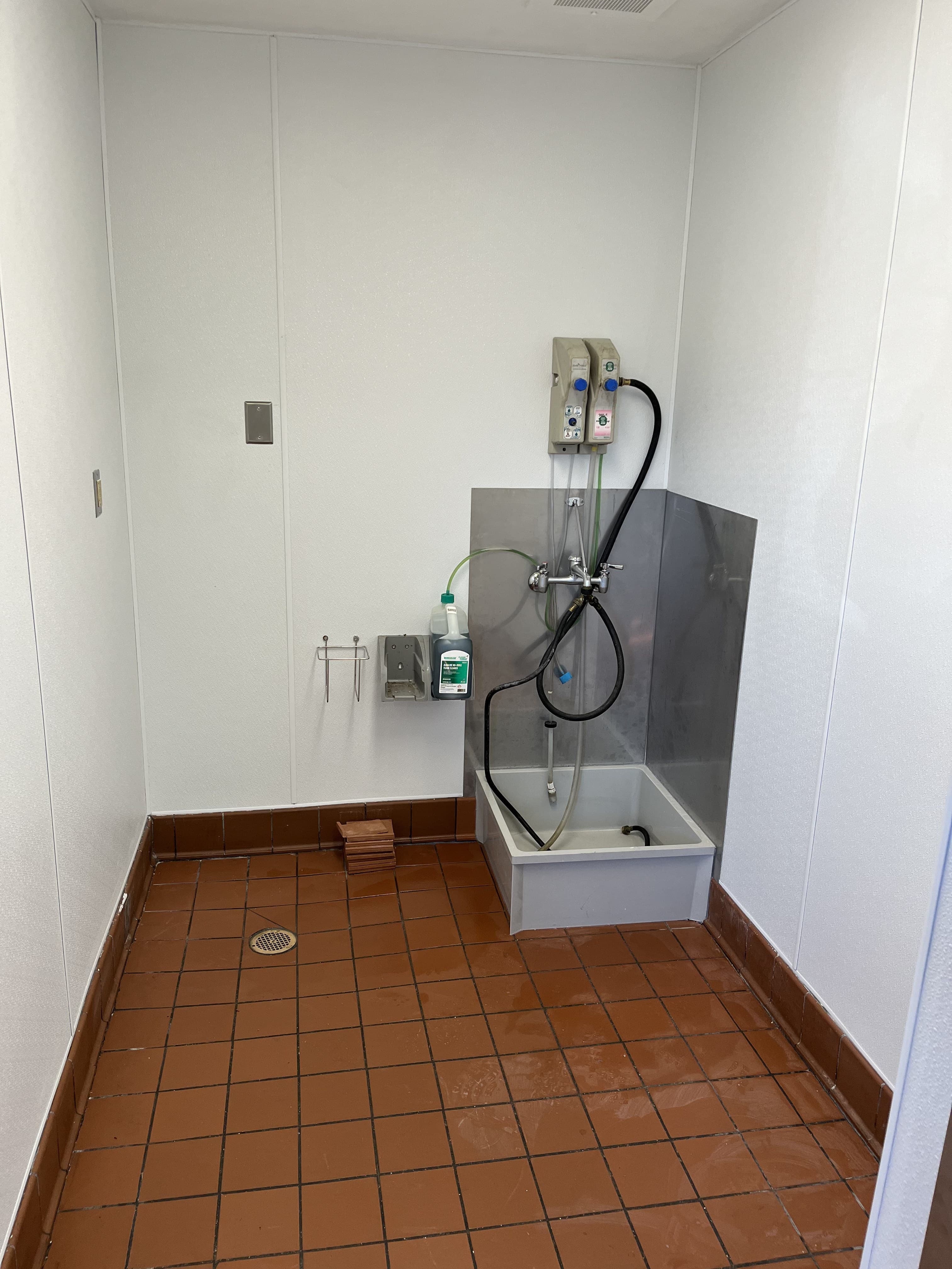 Utility sink area with finished walls and floor tile.