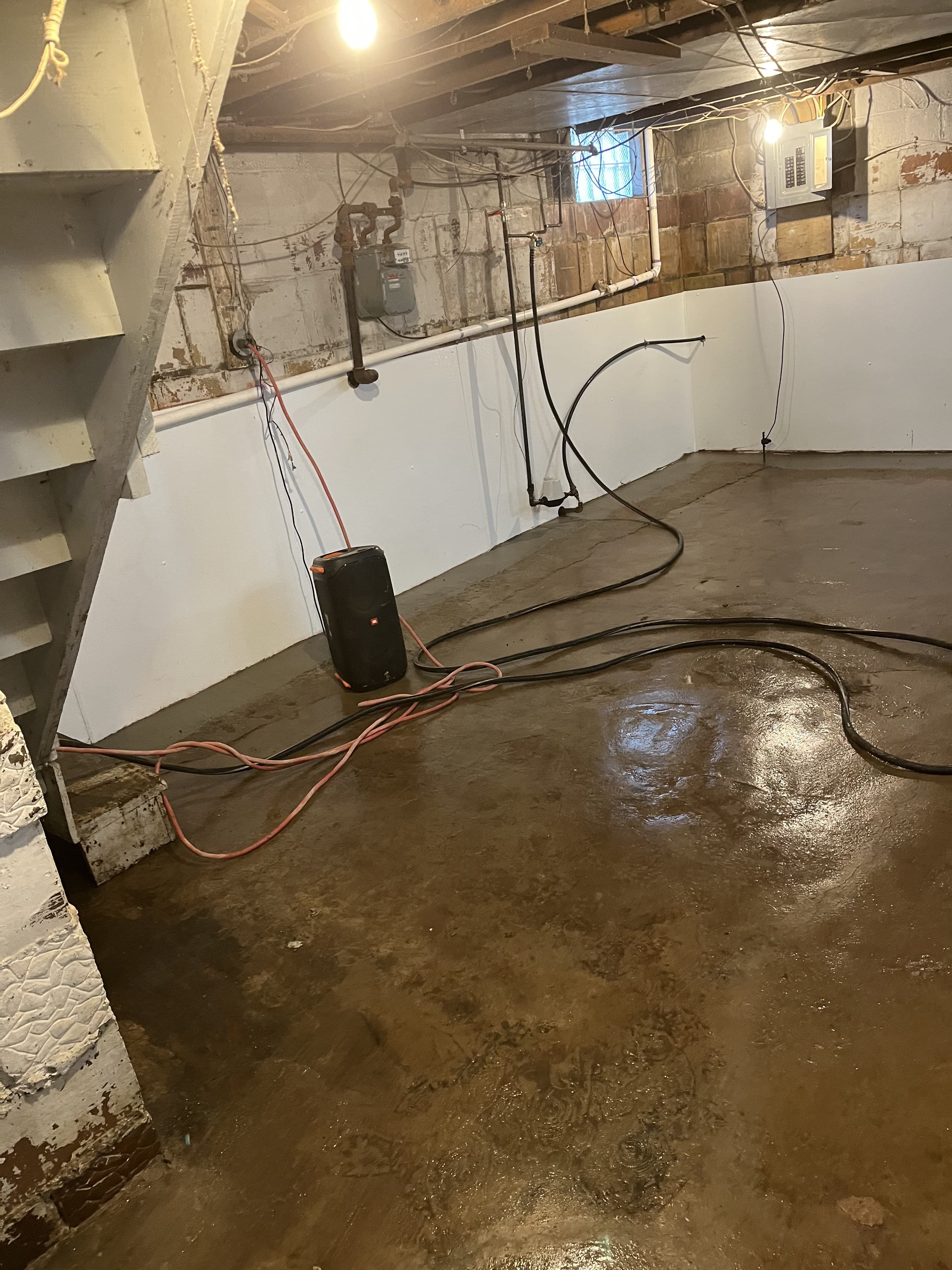 Finished basement repair area with walls and floor visible.