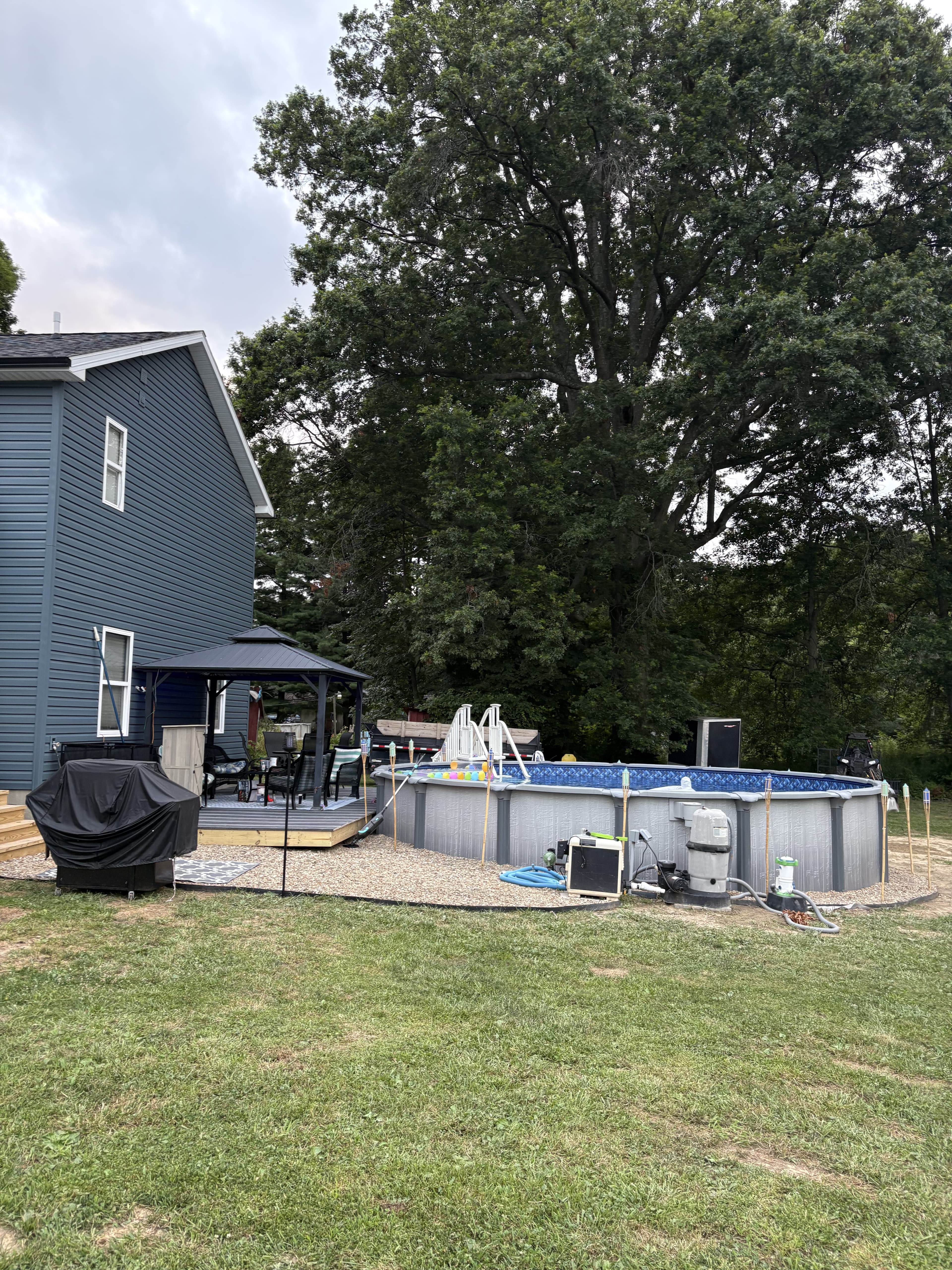 Finished backyard with deck, pool, and covered outdoor sitting area.