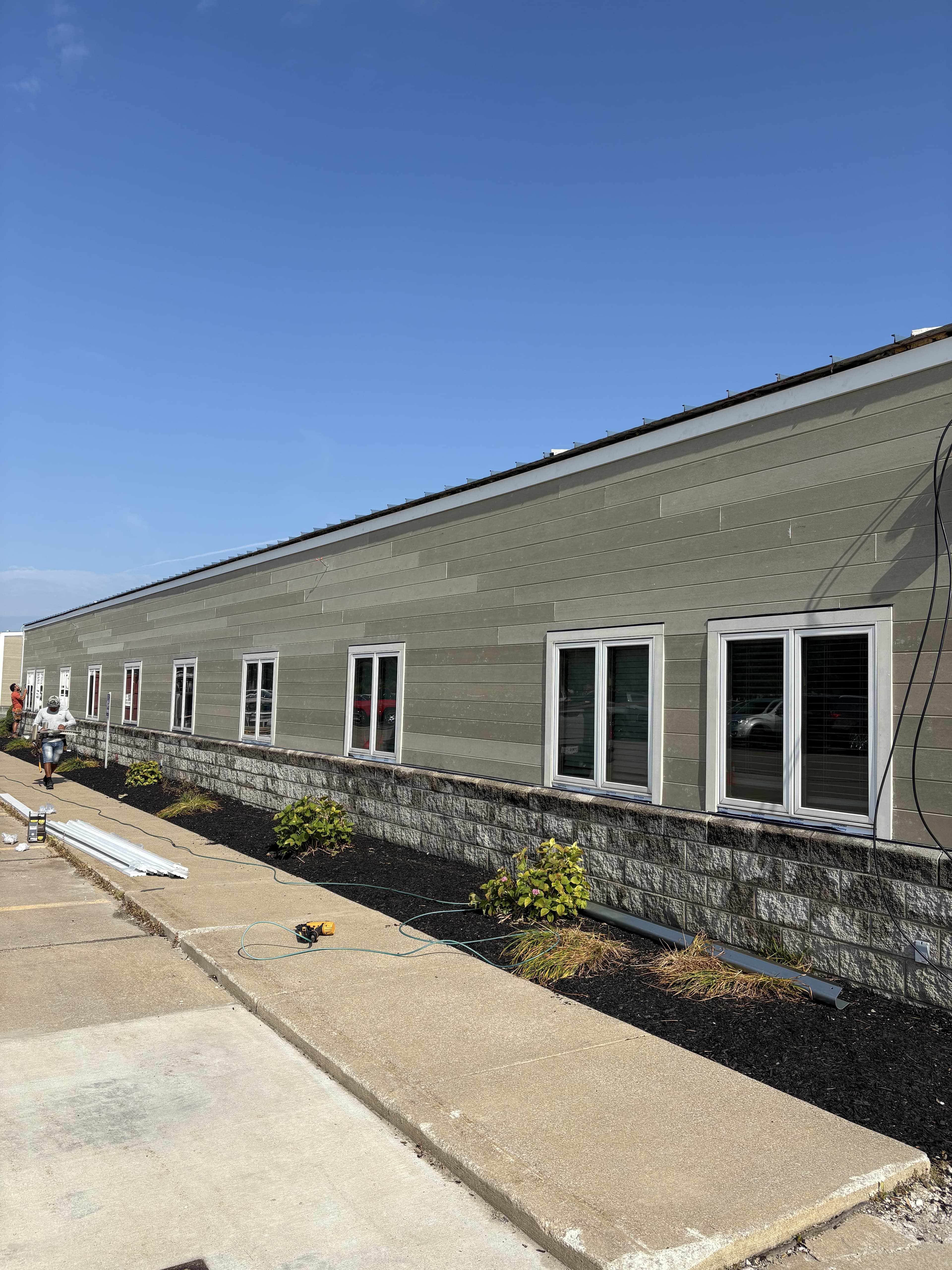 Commercial building exterior with finished siding and stone base.