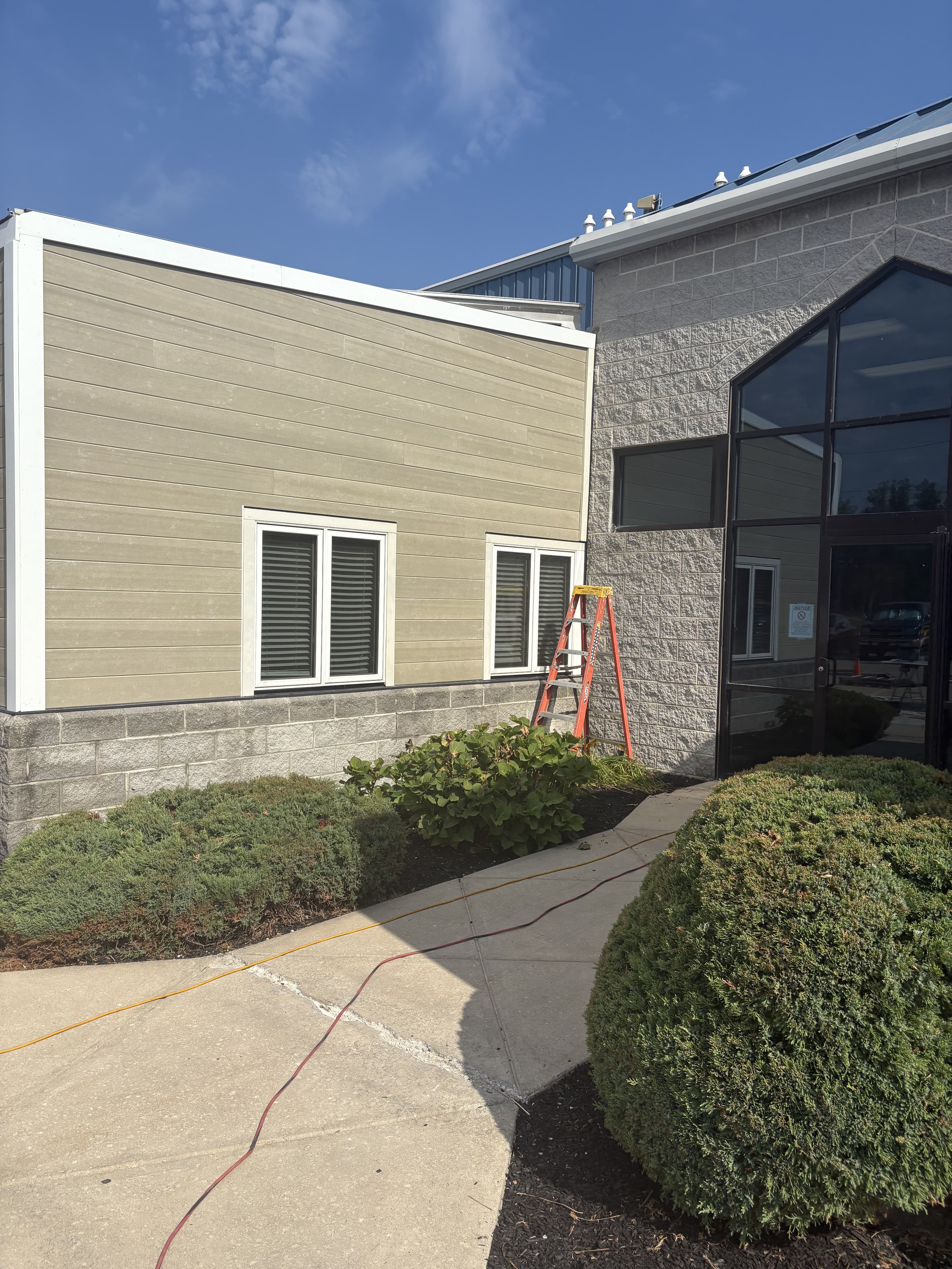 Commercial building approach with landscaping and finished exterior surfaces.