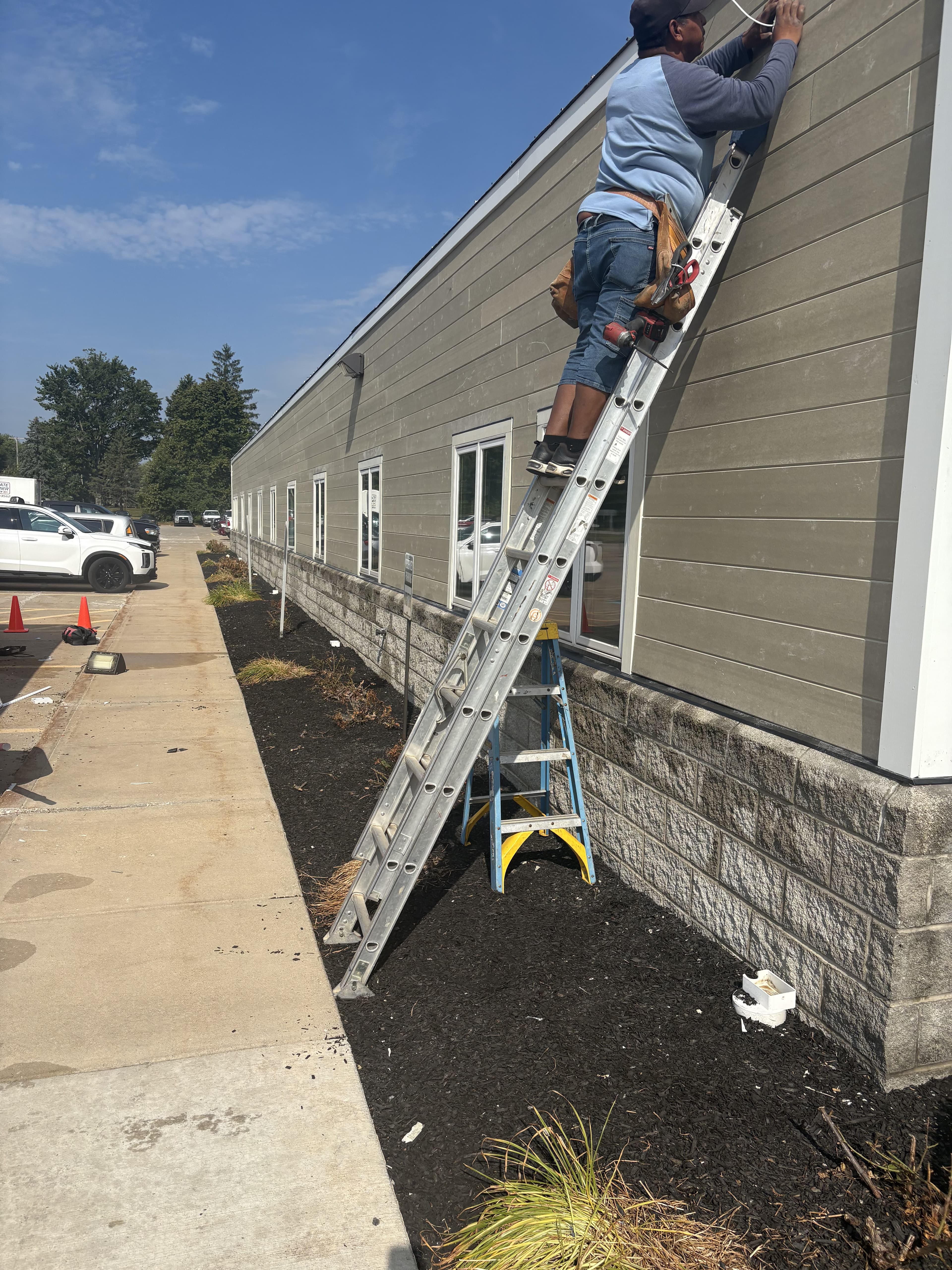 Commercial exterior side with ladder and siding improvements.