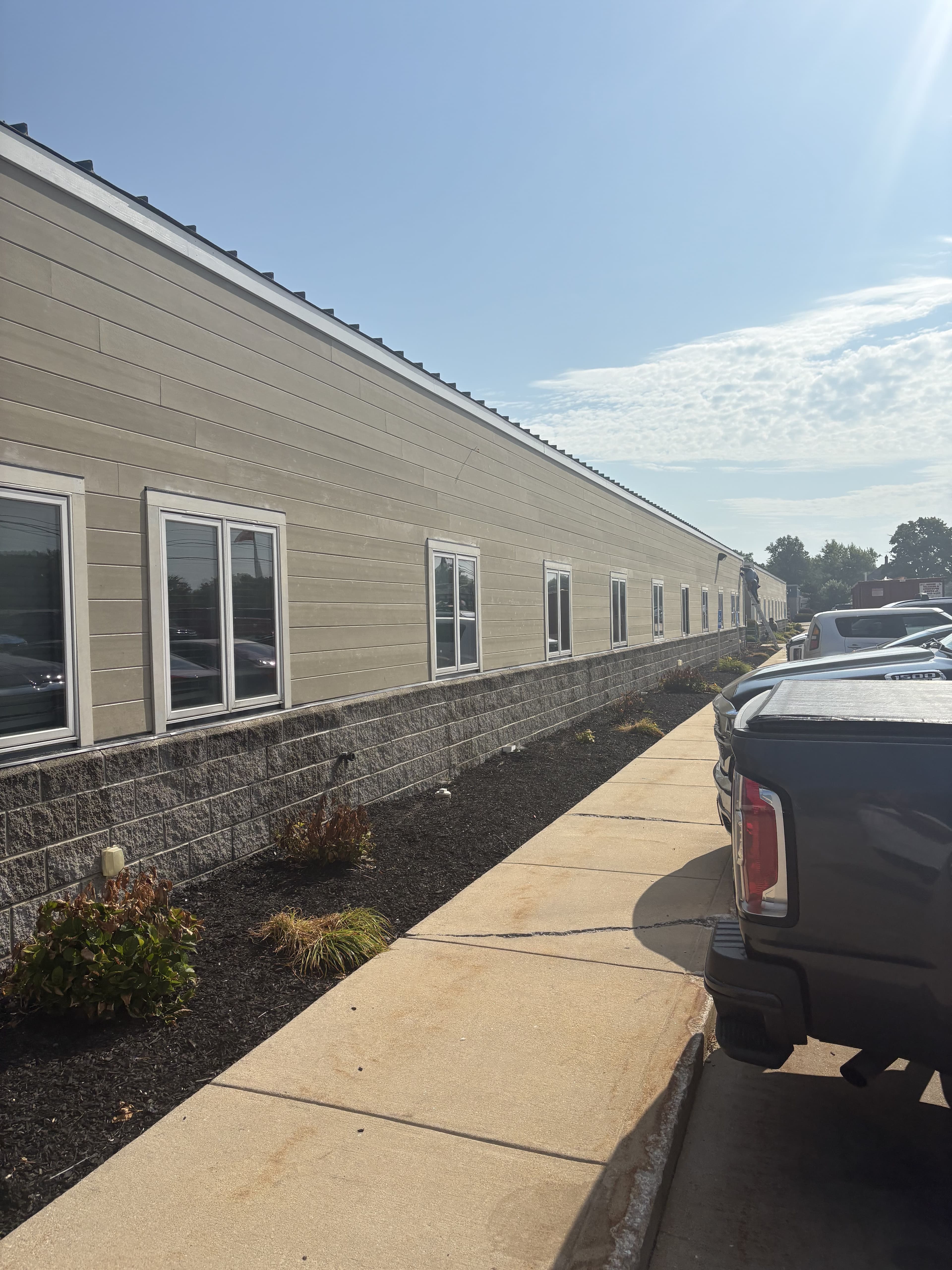 Extended exterior corridor view along a commercial building.