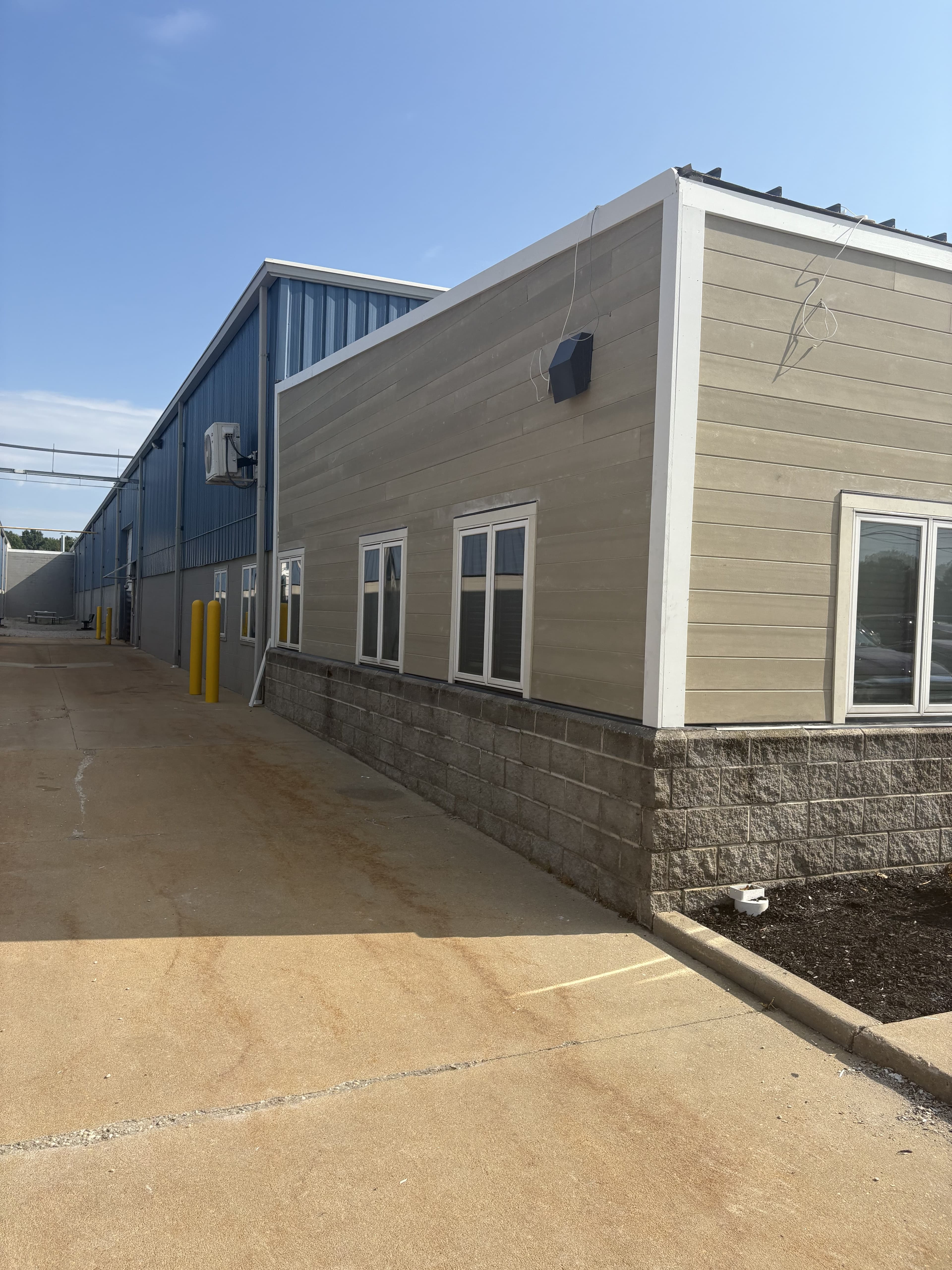 Rear service drive along a finished commercial building exterior.