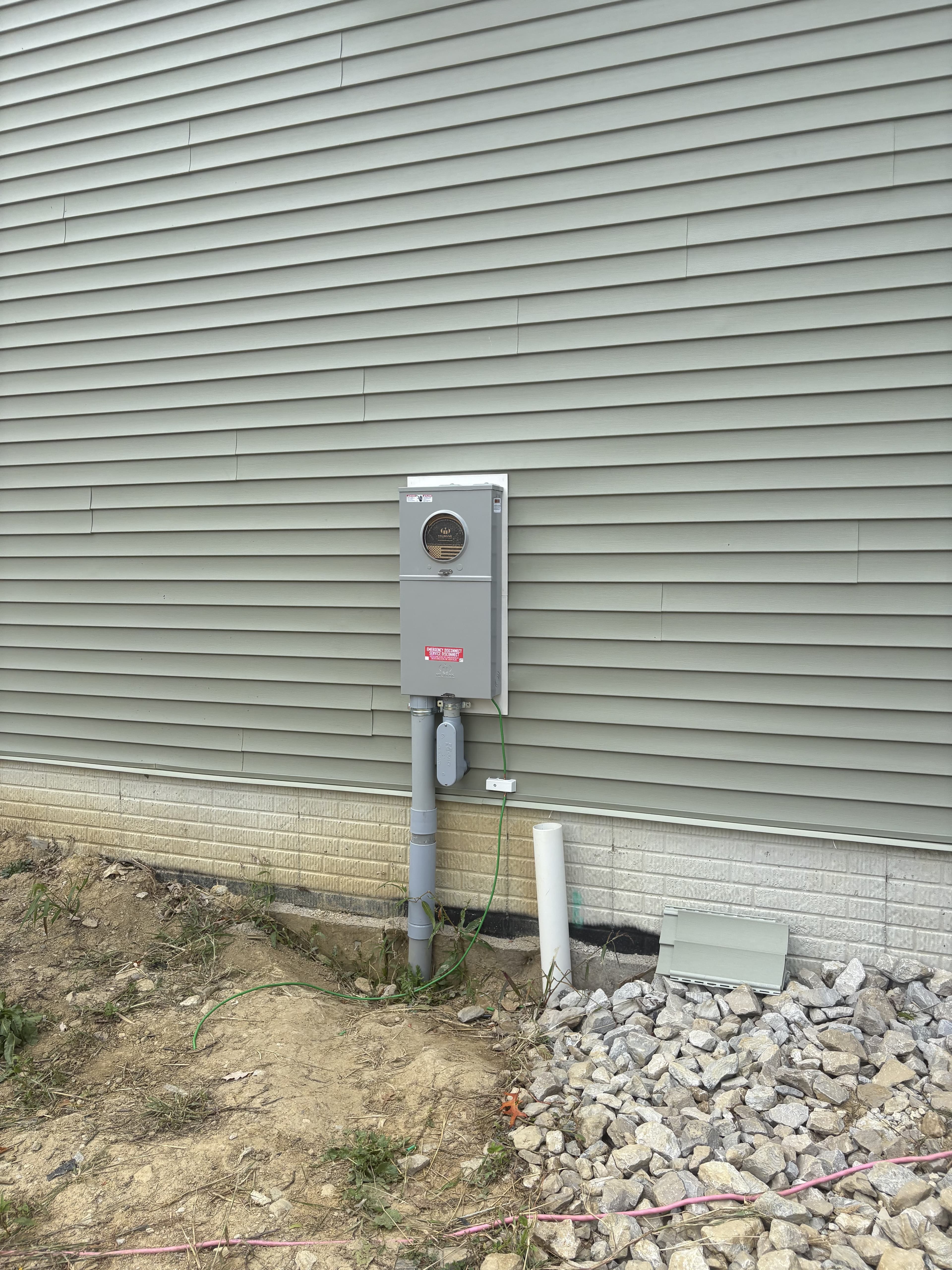 Exterior meter and electrical service mounted to siding.