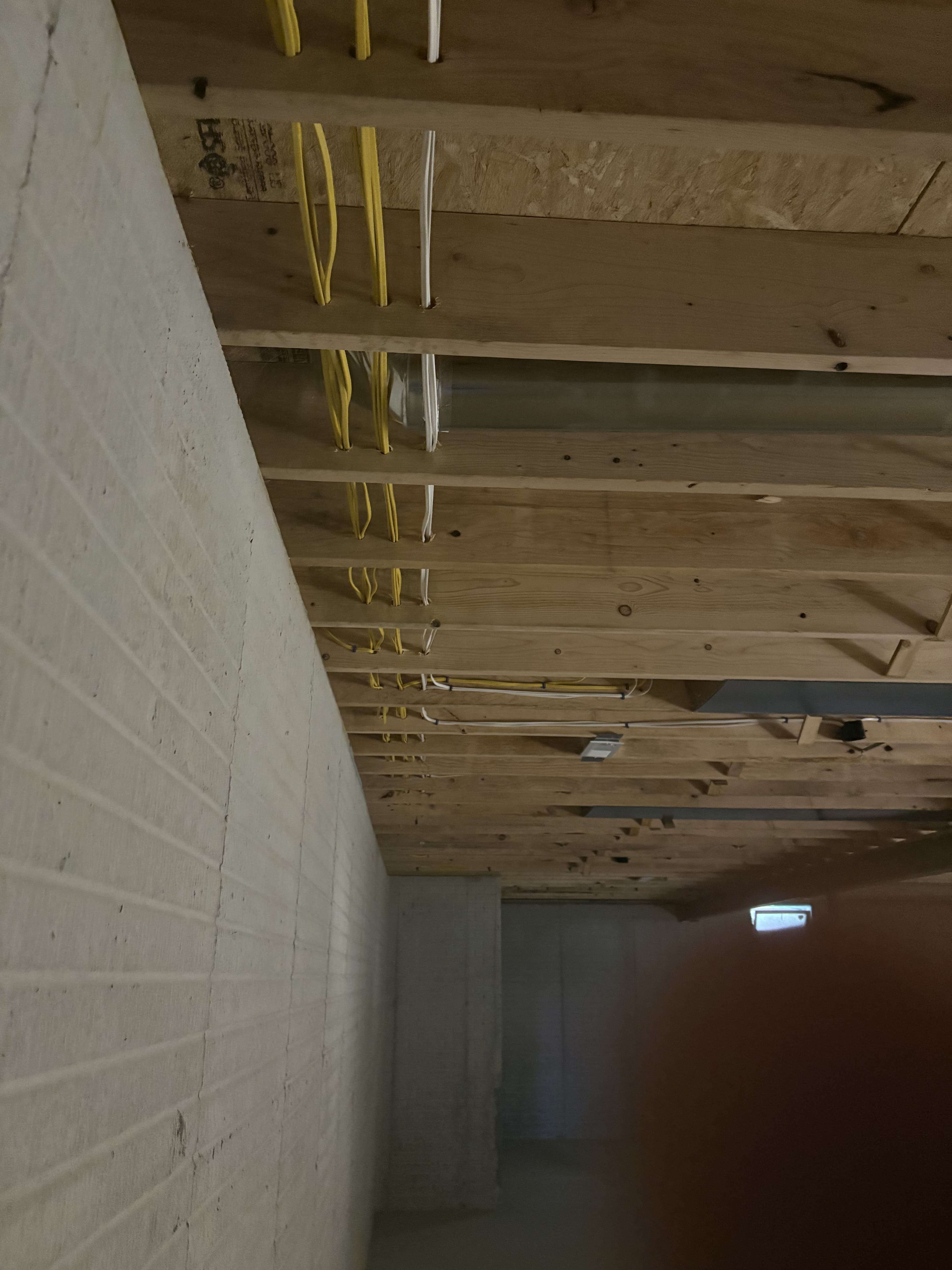 Electrical work visible across an unfinished ceiling area.