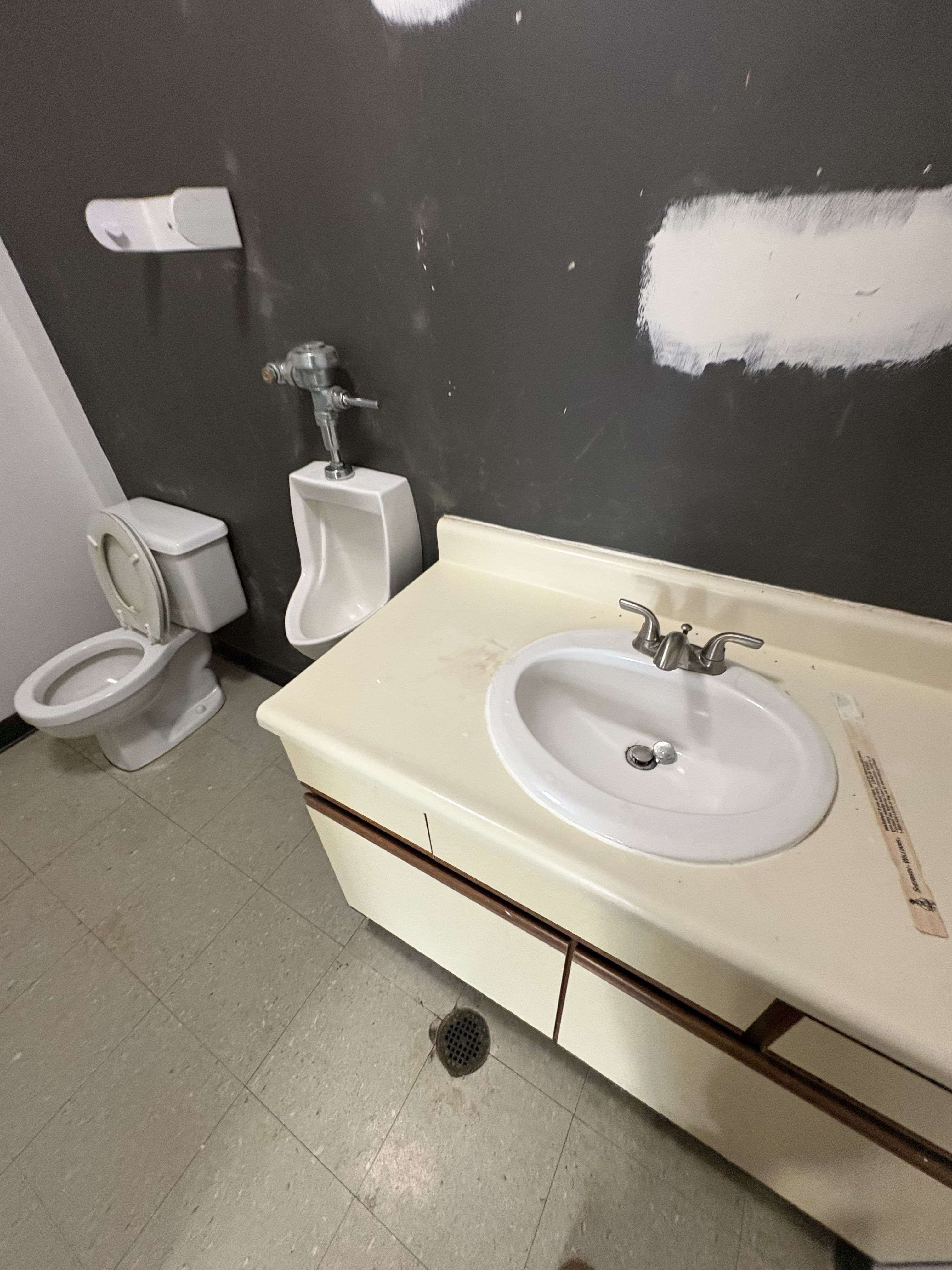 Existing commercial restroom fixture area before demolition and rebuild work.