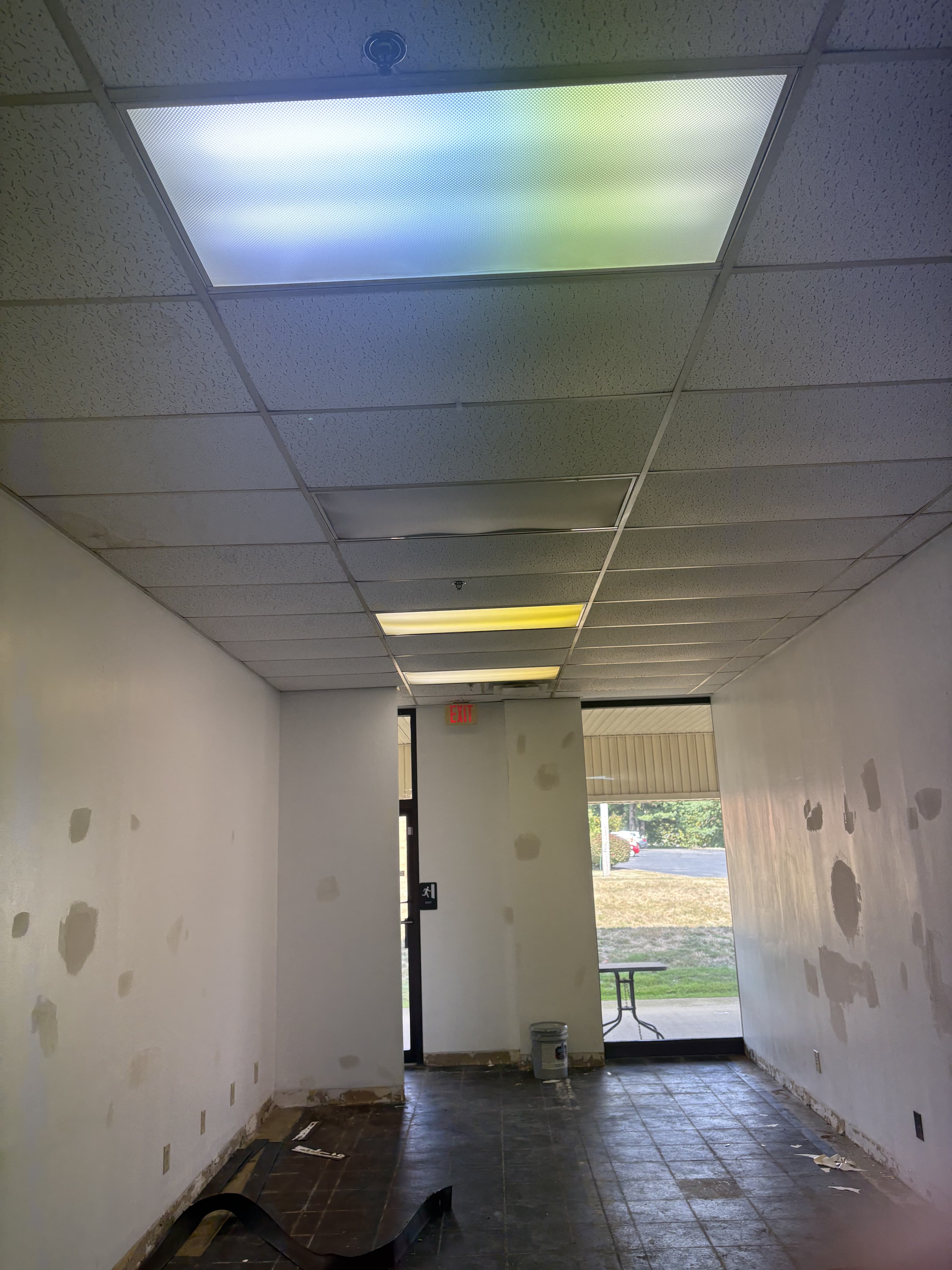 Commercial corridor with finished walls and ceiling grid in place.
