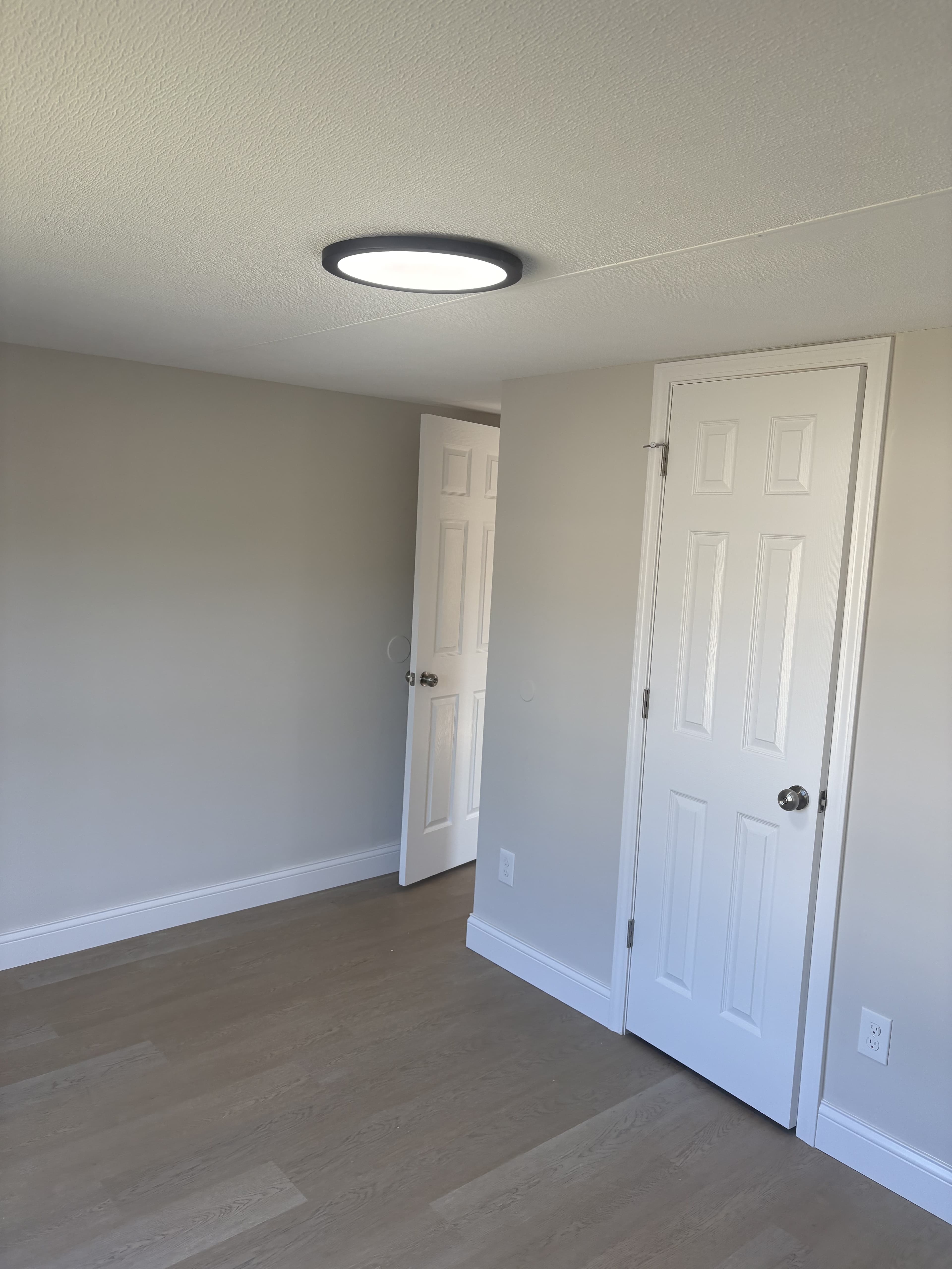 Finished residential room with light walls and ceiling fan.