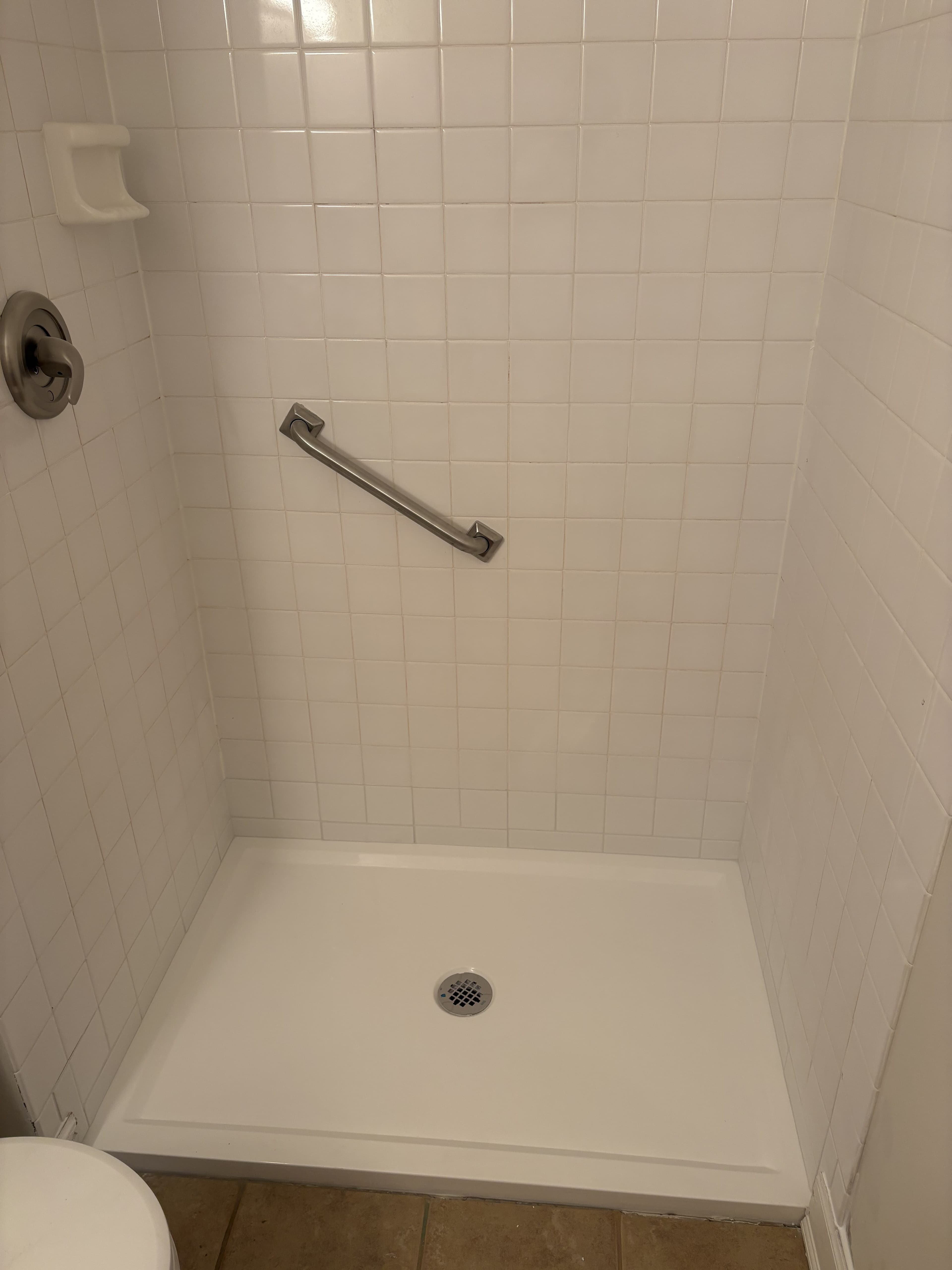 Finished shower base with clean wall tile detail.