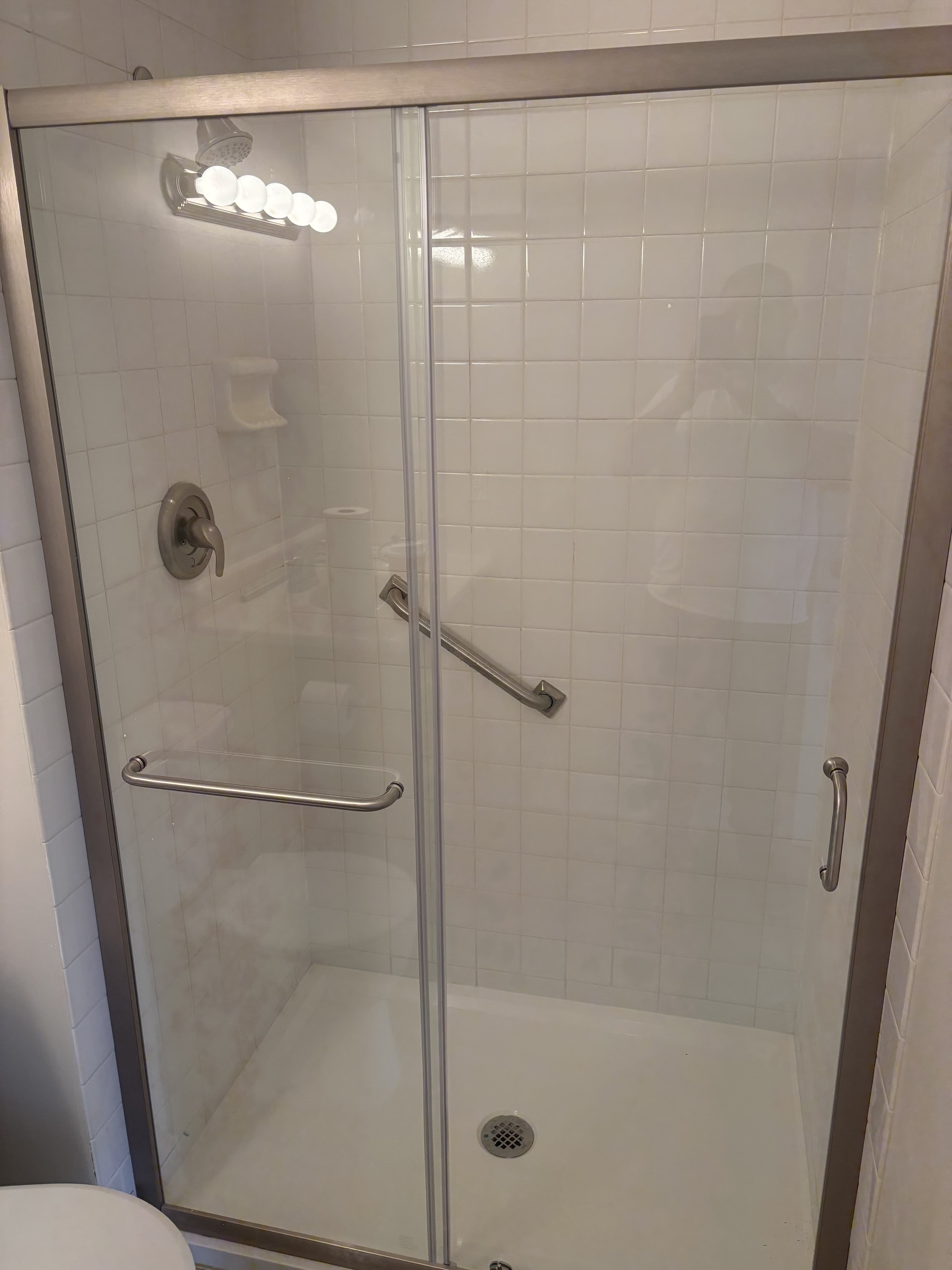 Finished shower enclosure with glass doors.